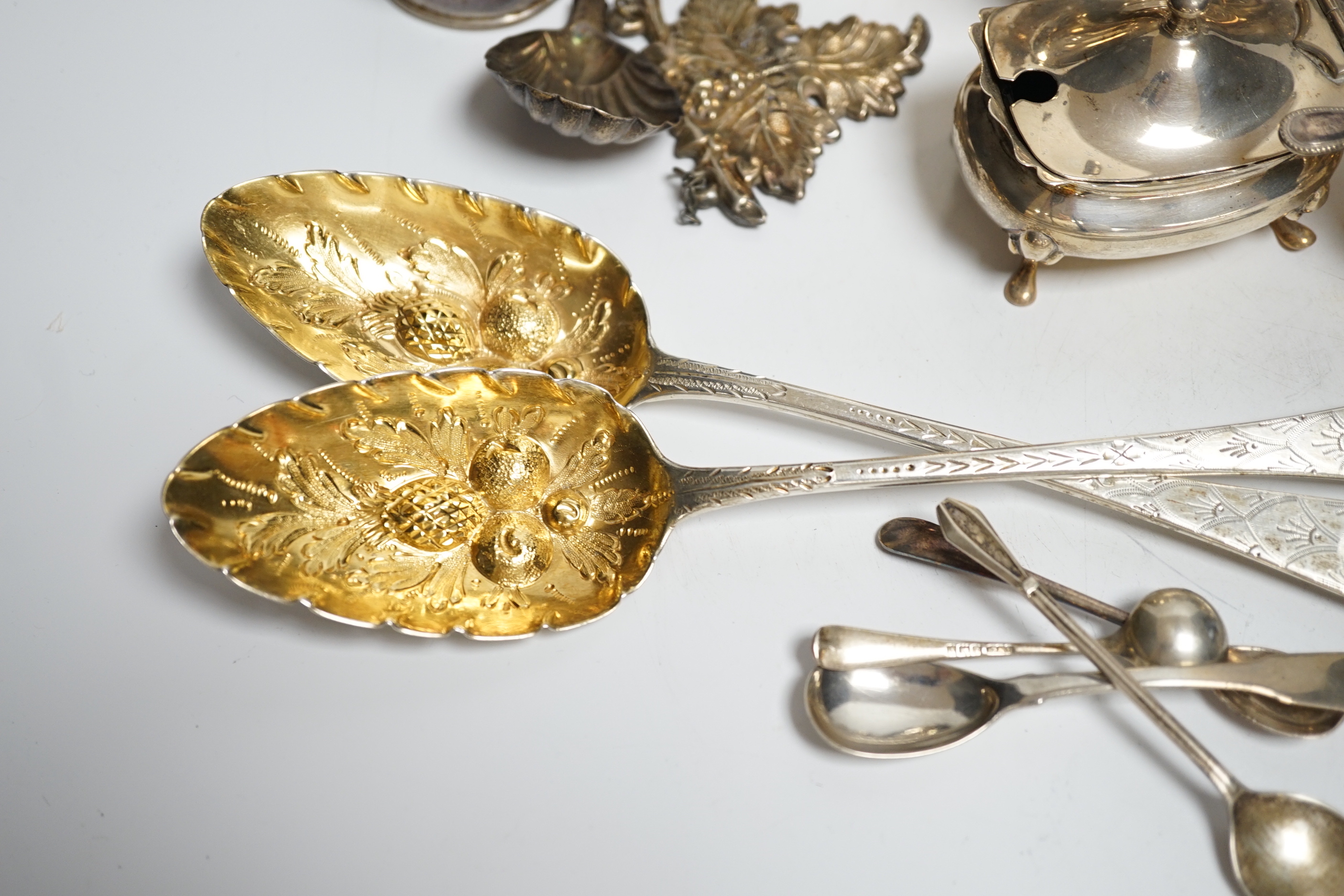 A George VI silver mug, Birmingham, 1937, 11.5cm with engraved inscription to Wing Commander E.E.M Angell, a pair of George III Old English pattern berry spoons, a George IV silver caddy spoons and other items including